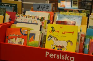 Bilderböcker på persiska i boktråg.