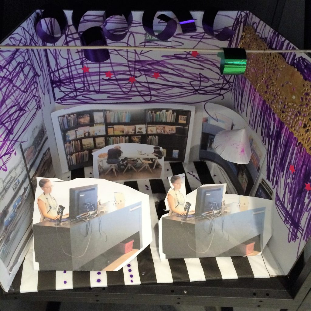 Ett barns modell i en kartong av ett bibliotek med inredning: papper, collageteknik, tusch