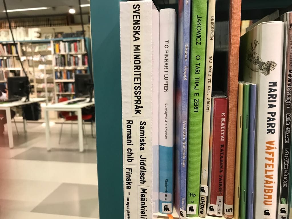 Bild på en bokhylla med Sveriges fem minoritetsspråk.